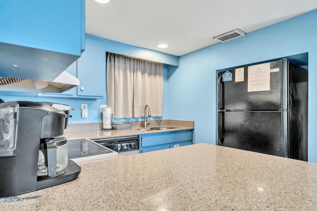 kitchen with visible vents, freestanding refrigerator, blue cabinetry, a sink, and recessed lighting