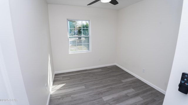 spare room with dark hardwood / wood-style flooring and ceiling fan