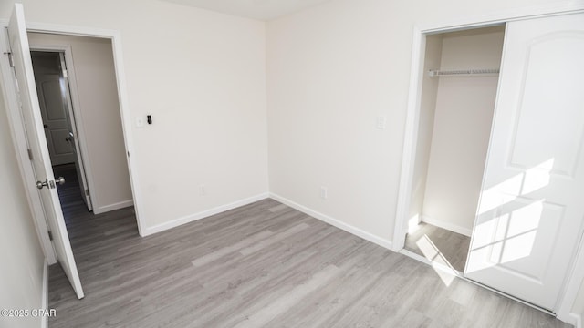 unfurnished bedroom with light hardwood / wood-style flooring and a closet