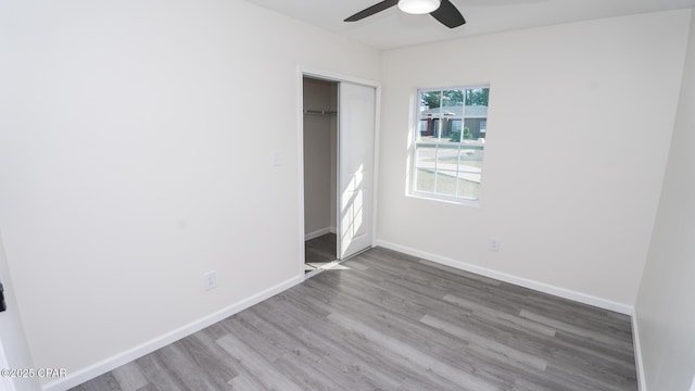 unfurnished bedroom with ceiling fan, hardwood / wood-style floors, and a closet