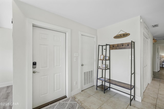 entryway with tile patterned flooring, visible vents, and baseboards