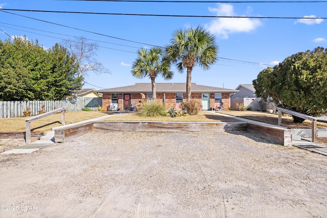 view of front of house featuring fence and brick siding