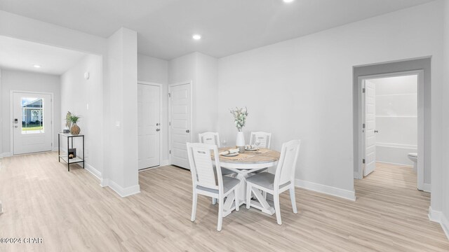 dining area with light wood-type flooring, baseboards, and recessed lighting