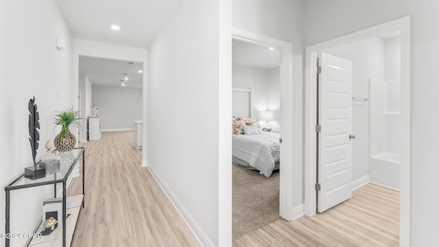 hall featuring recessed lighting, light wood-style flooring, and baseboards