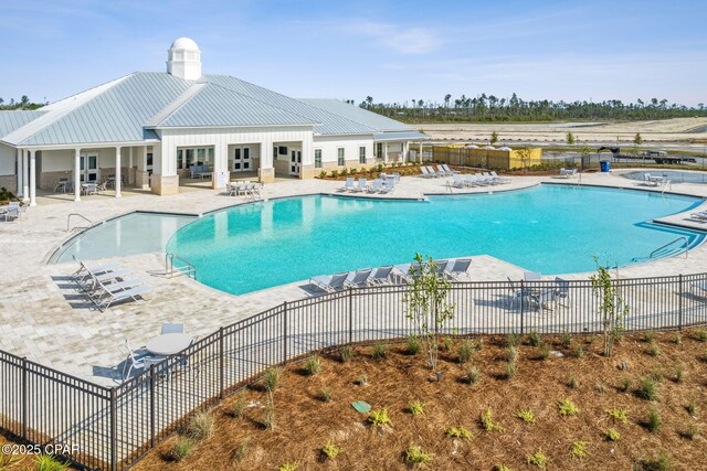 pool with a patio area and fence