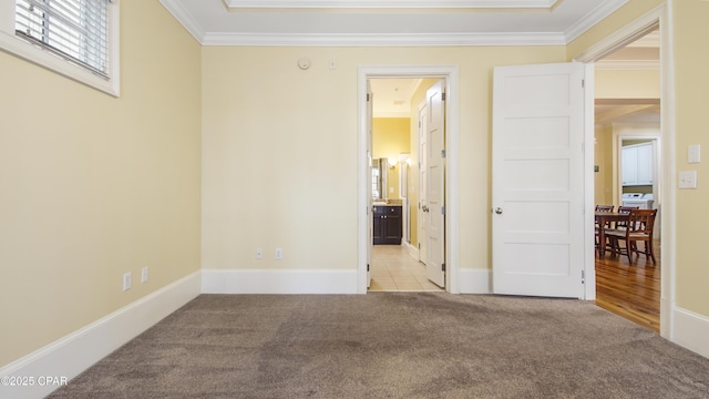 unfurnished bedroom featuring light carpet, ornamental molding, and baseboards