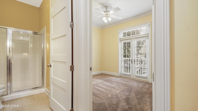 interior space featuring light carpet, a ceiling fan, baseboards, french doors, and crown molding