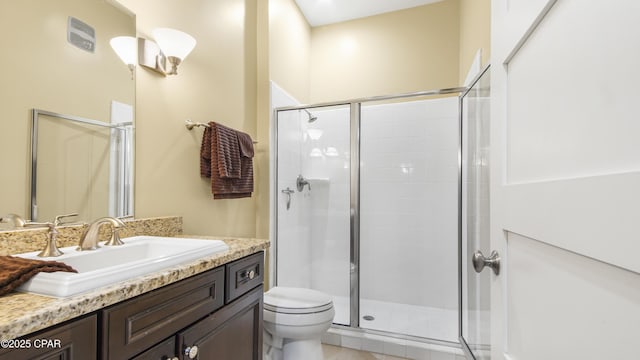 full bath featuring toilet, a stall shower, and vanity