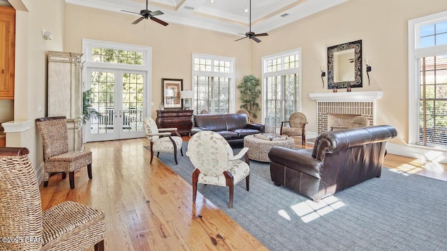 living area featuring a wealth of natural light, light wood-style flooring, and a high ceiling