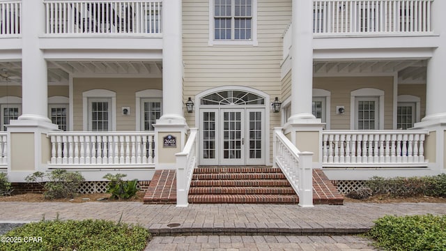 view of exterior entry featuring a porch and french doors