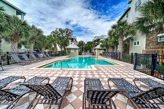 community pool with a patio area and fence