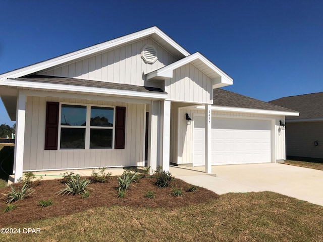 view of front of house with a garage, a shingled roof, and concrete driveway