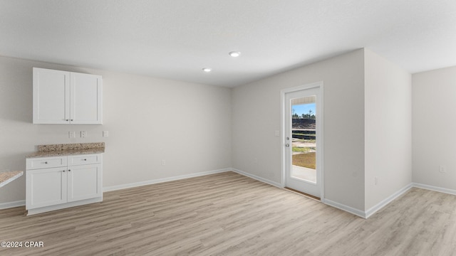 unfurnished dining area with light wood-style flooring, baseboards, and recessed lighting