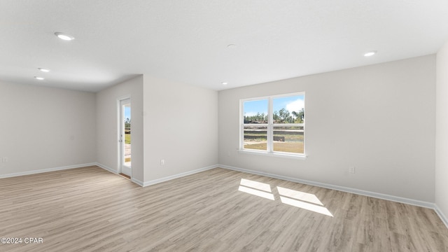 spare room with recessed lighting, light wood-type flooring, and baseboards