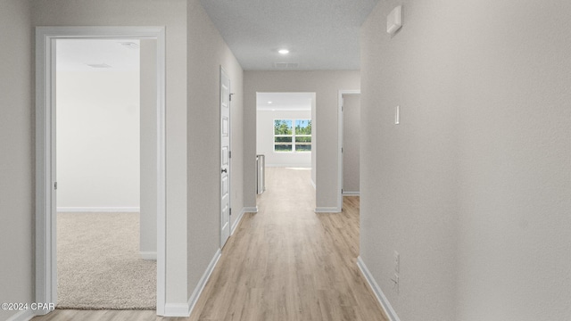 corridor featuring light wood-style floors and baseboards