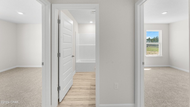 corridor featuring light carpet, baseboards, and recessed lighting