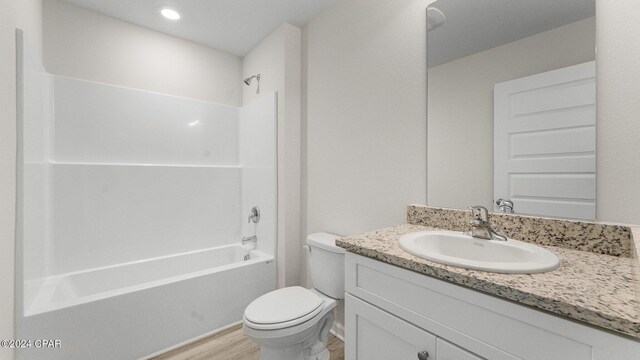 bathroom featuring toilet, shower / bathing tub combination, wood finished floors, and vanity