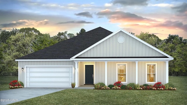 view of front of property featuring an attached garage, roof with shingles, concrete driveway, and a front lawn