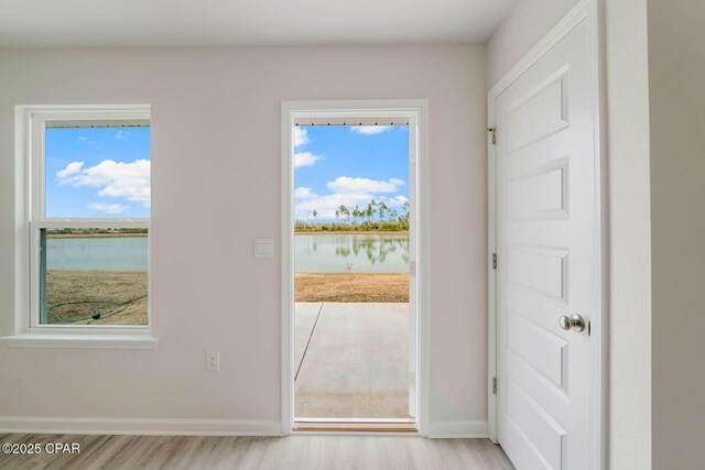 entryway featuring a water view and light hardwood / wood-style floors