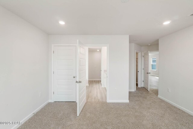 unfurnished bedroom featuring light carpet