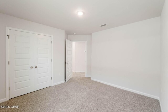 unfurnished bedroom with a closet and carpet flooring