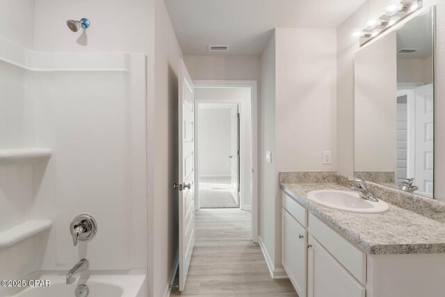 bathroom with vanity, bathing tub / shower combination, and hardwood / wood-style floors