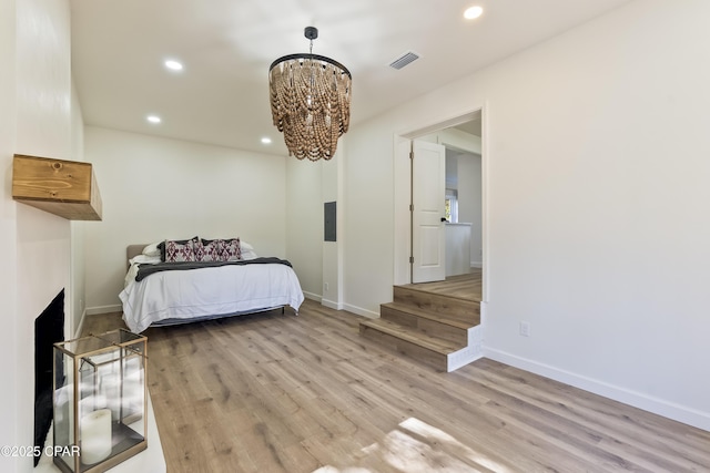 bedroom featuring a notable chandelier and light wood-type flooring