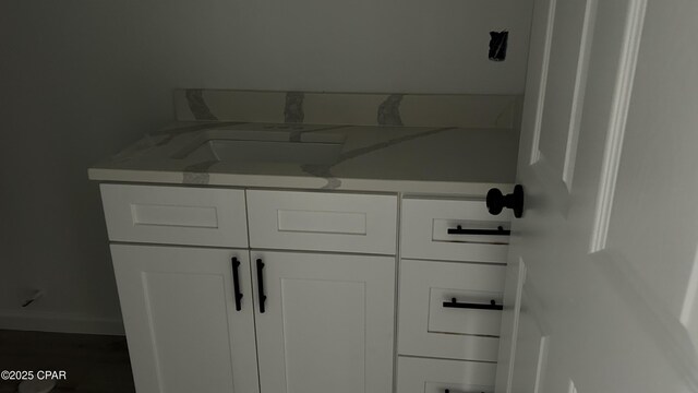 kitchen with vaulted ceiling, a center island, white cabinets, and light wood-type flooring