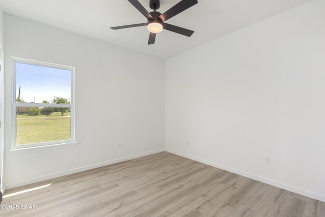 empty room with ceiling fan, baseboards, and wood finished floors