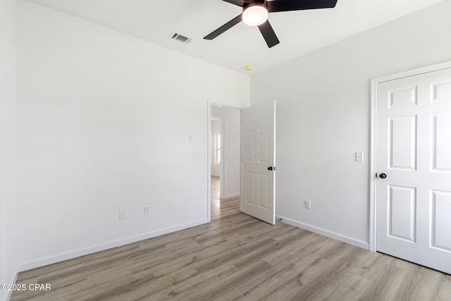 unfurnished bedroom featuring baseboards, a ceiling fan, light wood finished floors, and visible vents