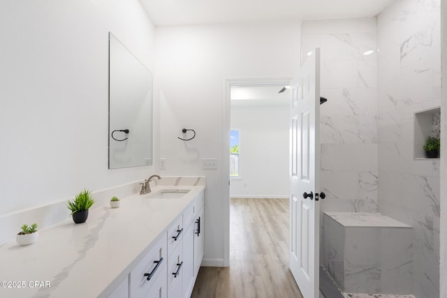 full bathroom with baseboards, walk in shower, wood finished floors, and vanity