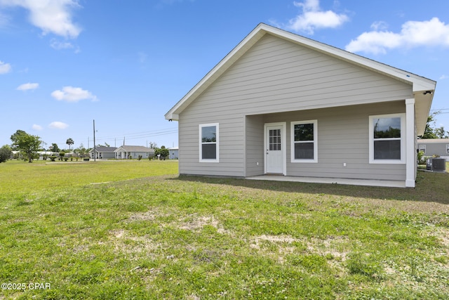 rear view of property featuring a yard and central AC