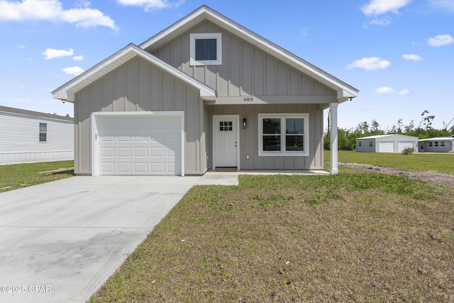 view of front of home featuring an attached garage, driveway, board and batten siding, and a front yard