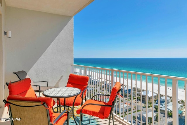 balcony featuring a view of the beach and a water view