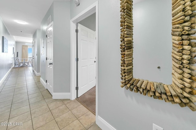 hallway featuring light tile patterned floors, visible vents, and baseboards