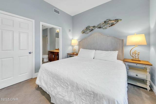 bedroom featuring baseboards, visible vents, carpet floors, and ensuite bathroom