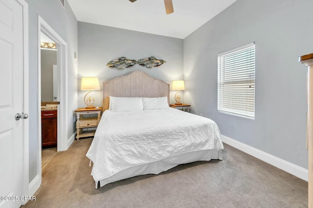 bedroom featuring ceiling fan, ensuite bath, light carpet, and baseboards