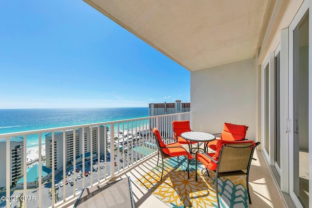 balcony with a water view and a view of the beach