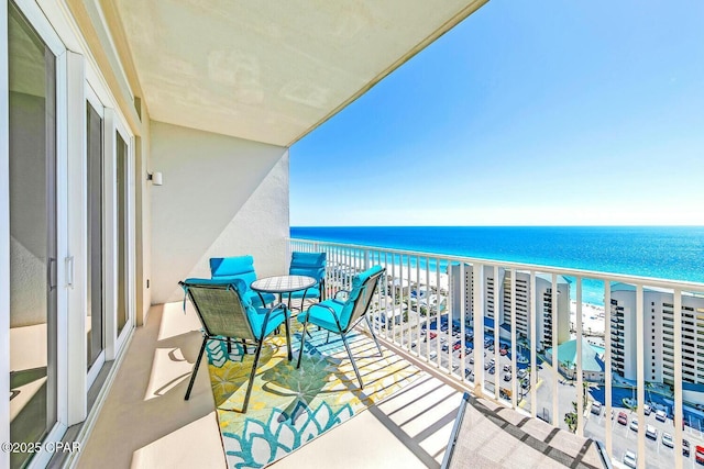 balcony with a water view and a beach view