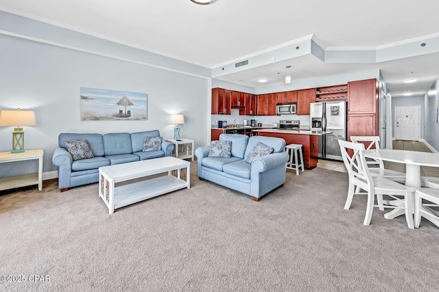 living area featuring visible vents, ornamental molding, and light carpet