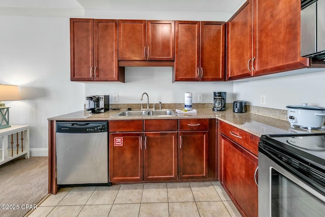kitchen featuring light stone countertops, stainless steel appliances, reddish brown cabinets, and a sink