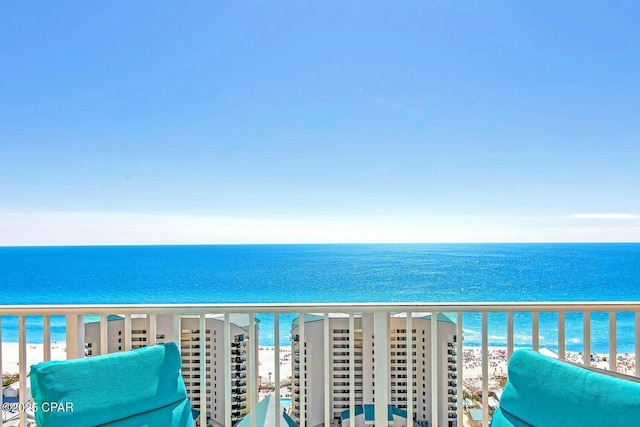 balcony featuring a beach view and a water view