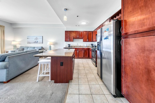 kitchen featuring open floor plan, a center island, stainless steel appliances, a breakfast bar area, and light tile patterned floors