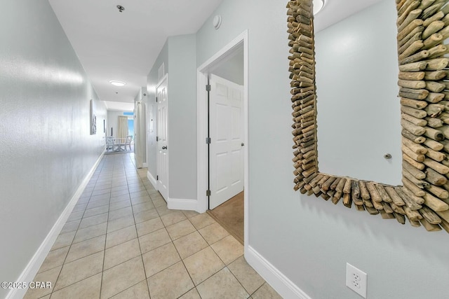 corridor with light tile patterned floors and baseboards
