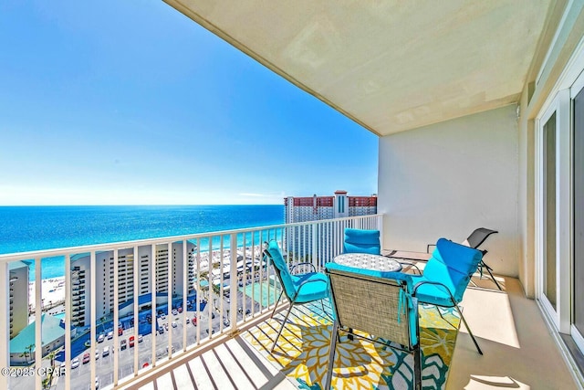 balcony featuring a beach view and a water view