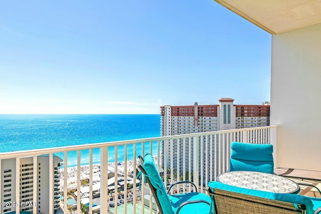 balcony featuring a view of the beach and a water view