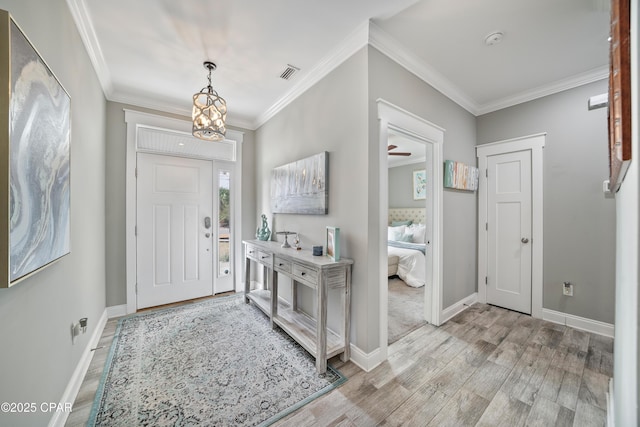 entrance foyer with light hardwood / wood-style flooring and ornamental molding