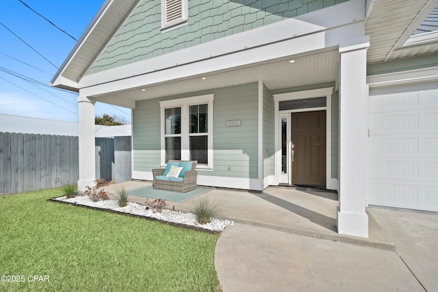 doorway to property with a garage, a yard, and a porch