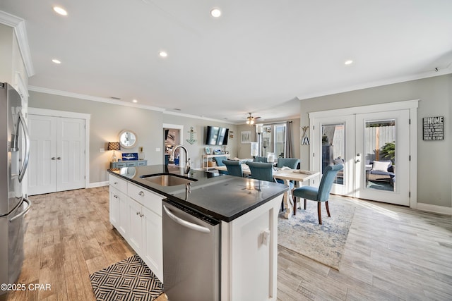 kitchen featuring sink, appliances with stainless steel finishes, white cabinetry, an island with sink, and french doors