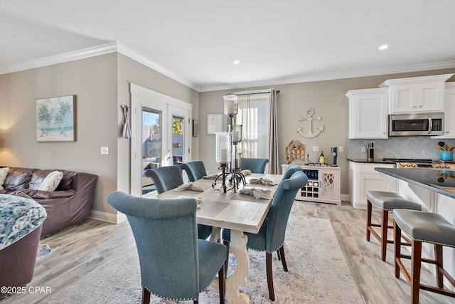 dining room with crown molding, light wood-type flooring, and french doors